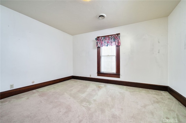 carpeted spare room featuring baseboards