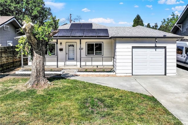 217 N Sacramento, Willows, CA 95988 - ranch-style house with an attached garage, a porch, roof mounted solar panels, driveway, and a front lawn