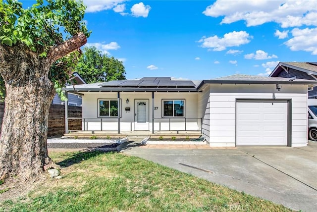 217 N Sacramento, Willows, CA 95988 - ranch-style home with a porch, solar panels, an attached garage, and concrete driveway
