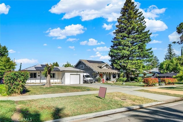 217 N Sacramento, Willows, CA 95988 - view of front of home with a garage, roof mounted solar panels, a front lawn, and concrete driveway
