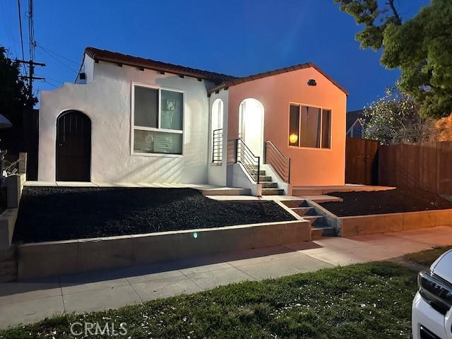 mediterranean / spanish-style house featuring stucco siding and fence