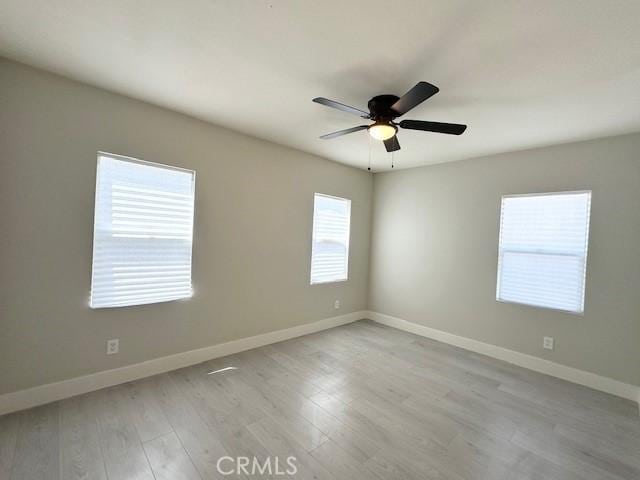 unfurnished room featuring light wood-type flooring, baseboards, and ceiling fan