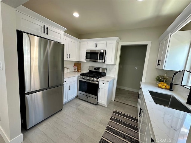 2209 W Glendon Way, Alhambra, CA 91803 - kitchen with appliances with stainless steel finishes, a sink, white cabinets, light stone countertops, and recessed lighting