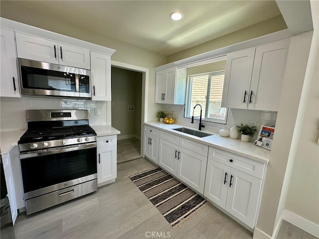 2209 W Glendon Way, Alhambra, CA 91803 - kitchen featuring appliances with stainless steel finishes, a sink, decorative backsplash, white cabinetry, and baseboards