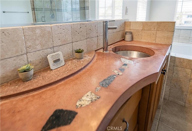 full bathroom featuring a shower stall, tasteful backsplash, vanity, and a relaxing tiled tub