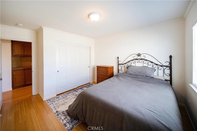 bedroom featuring light wood-style flooring, a closet, and ornamental molding