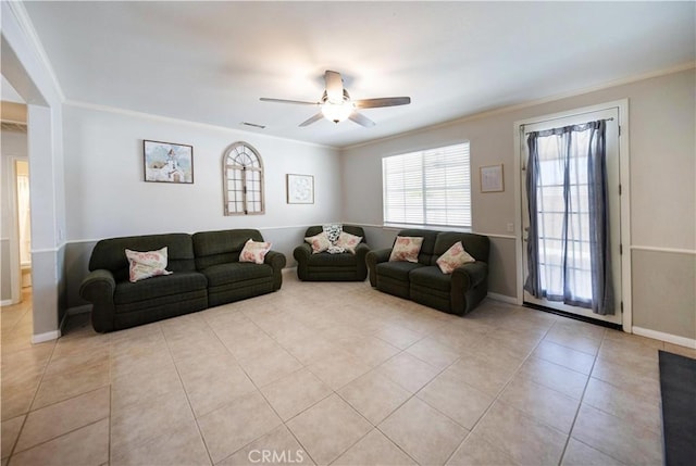 tiled living area featuring ornamental molding, baseboards, and a ceiling fan