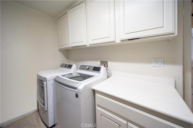laundry room featuring cabinet space, washing machine and dryer, and light tile patterned flooring