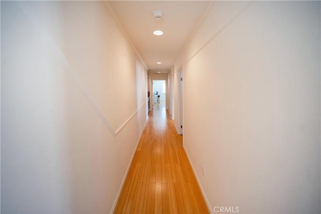 hallway with light wood-style flooring, baseboards, and recessed lighting