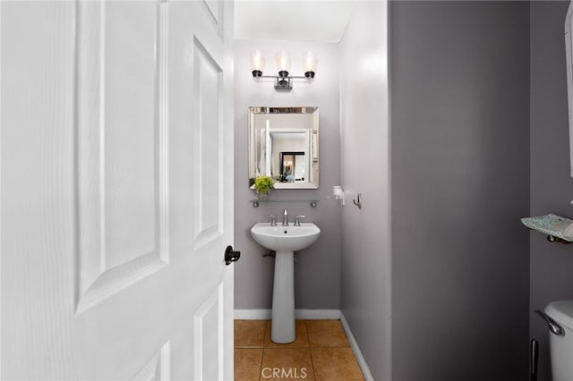 half bath featuring toilet, tile patterned floors, and baseboards