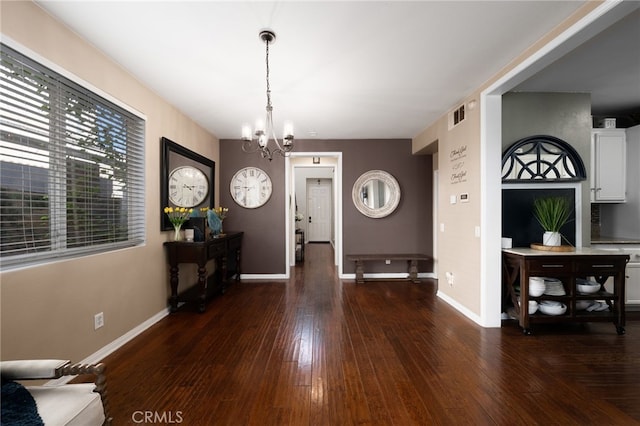 foyer entrance featuring a chandelier, hardwood / wood-style floors, baseboards, and visible vents