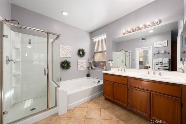 bathroom with a shower stall, a garden tub, a sink, and visible vents