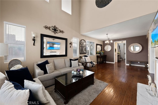 living area featuring dark wood-type flooring, baseboards, and a chandelier