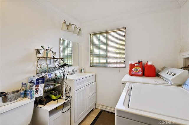 washroom with a sink, ornamental molding, washer and clothes dryer, and laundry area