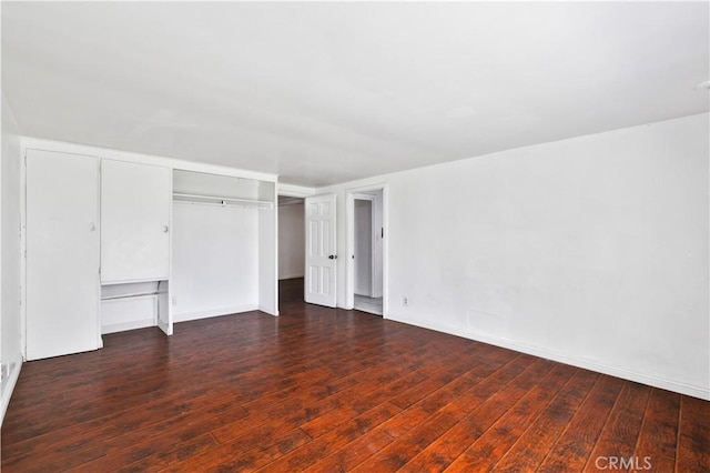 unfurnished bedroom featuring a closet, baseboards, and wood finished floors