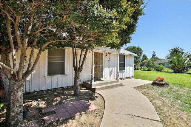 view of front of home featuring board and batten siding and a front lawn