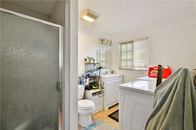 full bath with a shower stall, vanity, ornamental molding, toilet, and washer / dryer