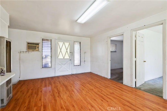 entrance foyer with a wall unit AC and wood finished floors