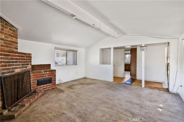 unfurnished living room featuring a fireplace, vaulted ceiling with beams, and carpet floors