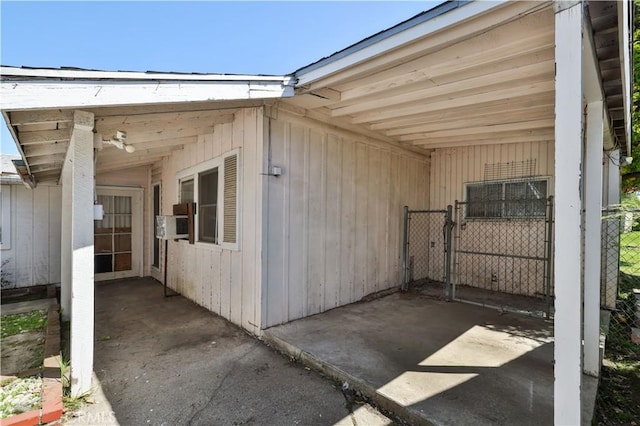 view of side of home featuring fence, a carport, cooling unit, and a gate