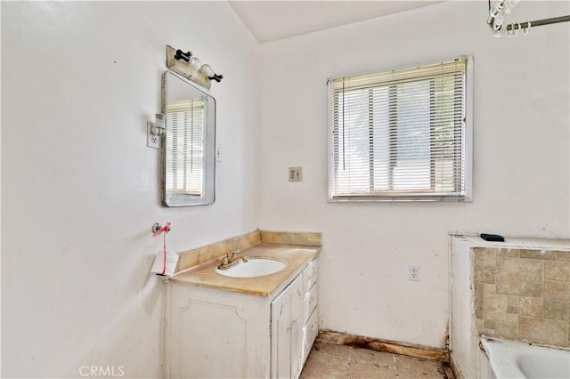 full bathroom with tile patterned floors, vanity, a bathing tub, and baseboards