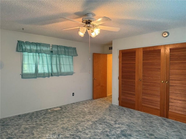 unfurnished bedroom with visible vents, a closet, a ceiling fan, a textured ceiling, and carpet floors