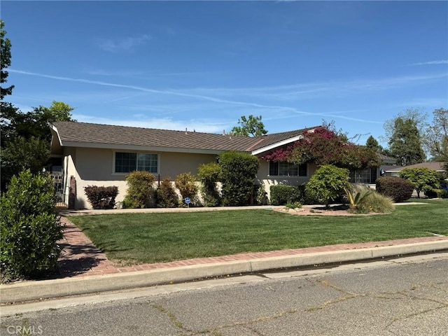 ranch-style home with stucco siding and a front yard