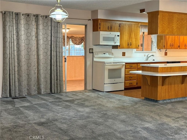 kitchen featuring white appliances, light countertops, carpet floors, brown cabinets, and a sink