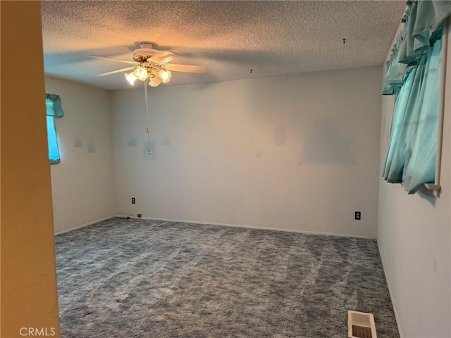 empty room with a textured ceiling, ceiling fan, carpet flooring, and visible vents