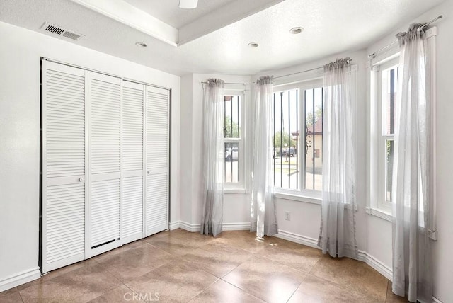 unfurnished bedroom with a closet, visible vents, recessed lighting, tile patterned floors, and baseboards