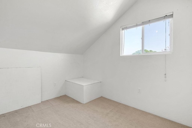 bonus room featuring light carpet and lofted ceiling