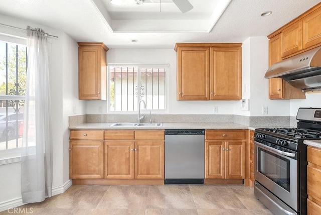 kitchen with appliances with stainless steel finishes, a healthy amount of sunlight, a sink, and under cabinet range hood