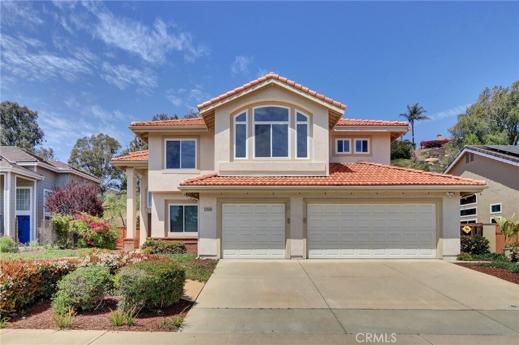 12050 Crest Rd, Poway, CA 92064 - mediterranean / spanish-style home featuring driveway, a tiled roof, an attached garage, and stucco siding