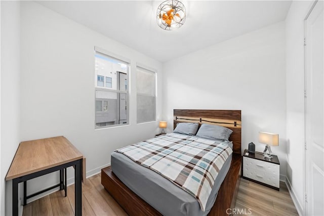 bedroom with baseboards and wood finished floors