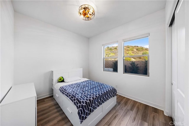 bedroom with dark wood-style flooring and baseboards