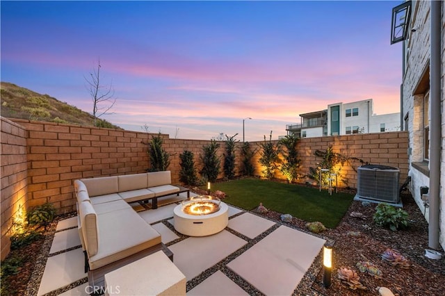 view of patio featuring an outdoor living space with a fire pit, a fenced backyard, and central AC unit