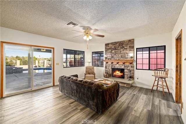 41018 40th St W, Palmdale, CA 93551 - living room featuring wood finished floors, ceiling fan, a fireplace, a textured ceiling, and baseboards
