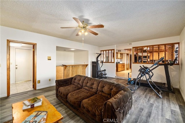 41018 40th St W, Palmdale, CA 93551 - living area with wood finished floors, a ceiling fan, a textured ceiling, and baseboards