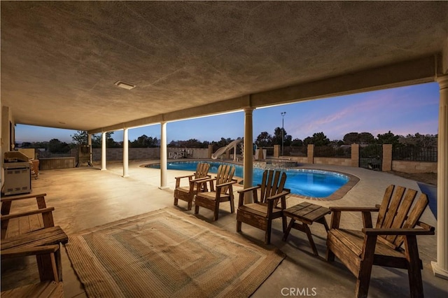 41018 40th St W, Palmdale, CA 93551 - pool at dusk featuring a water slide, a patio, and a fenced backyard