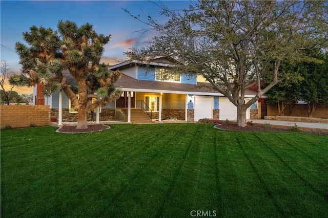 41018 40th St W, Palmdale, CA 93551 - rear view of property featuring a lawn, covered porch, driveway, and stone siding