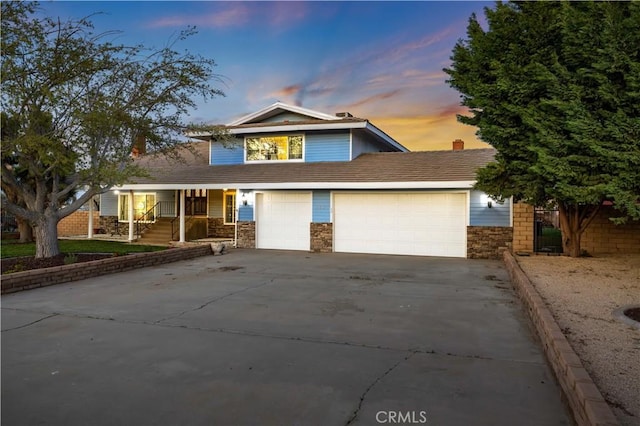 41018 40th St W, Palmdale, CA 93551 - traditional-style home with driveway, stone siding, a garage, and a porch