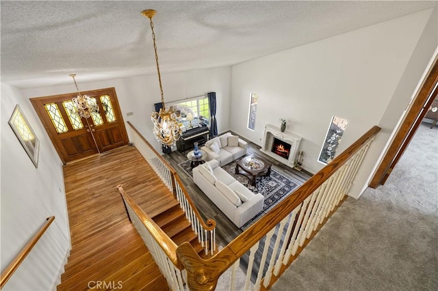 41018 40th St W, Palmdale, CA 93551 - living area featuring a chandelier, healthy amount of natural light, wood finished floors, a textured ceiling, and a lit fireplace
