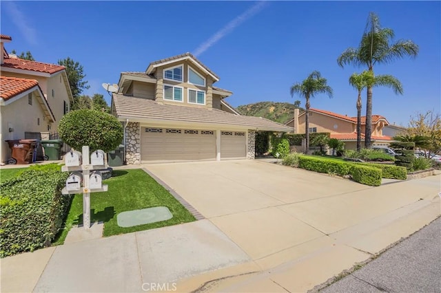 traditional-style house with a tiled roof, an attached garage, stone siding, and driveway
