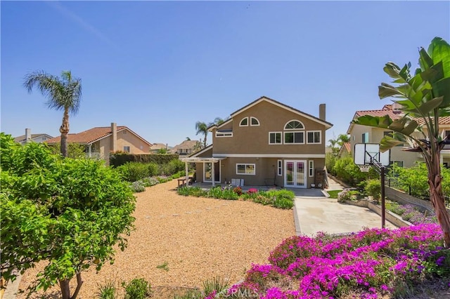rear view of property featuring a patio, french doors, and stucco siding