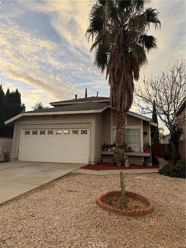 ranch-style home with a garage, driveway, and fence