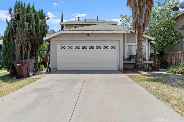traditional home featuring fence, a garage, and driveway