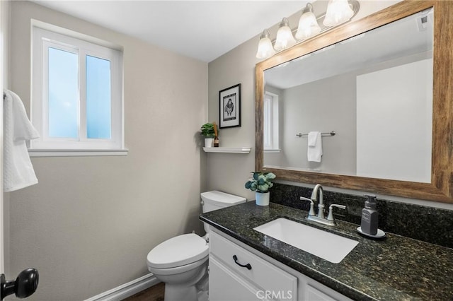 bathroom with vanity, baseboards, and toilet