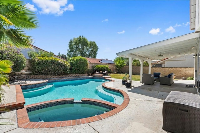 view of pool featuring a fenced backyard, a pool with connected hot tub, a patio area, and outdoor lounge area
