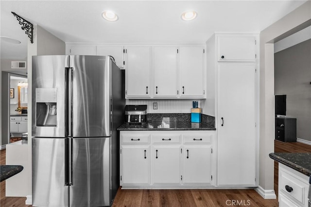 27884 Beacon St, Castaic, CA 91384 - kitchen featuring dark wood-style flooring, stainless steel fridge, dark stone countertops, white cabinetry, and visible vents