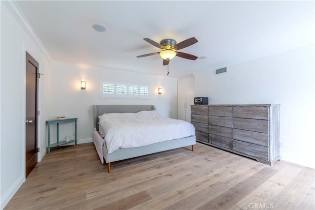 bedroom featuring ceiling fan, crown molding, light wood-style floors, and visible vents